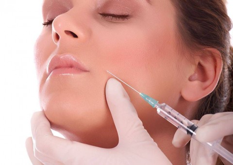 Beautiful woman getting botox injection against aging process.